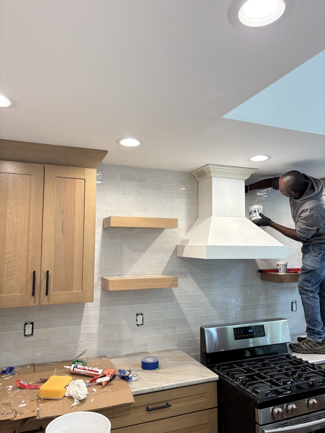 Finish carpenter working a plaster range hood while protecting the kitchen